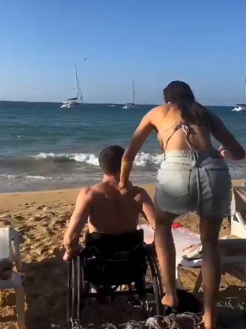 Novia lleva a joven en silla de ruedas al mar