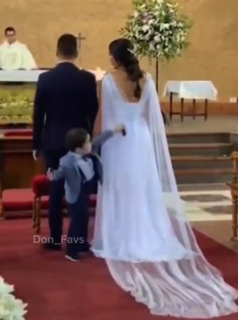 Captan a niño jugando con vestido de novia en boda
