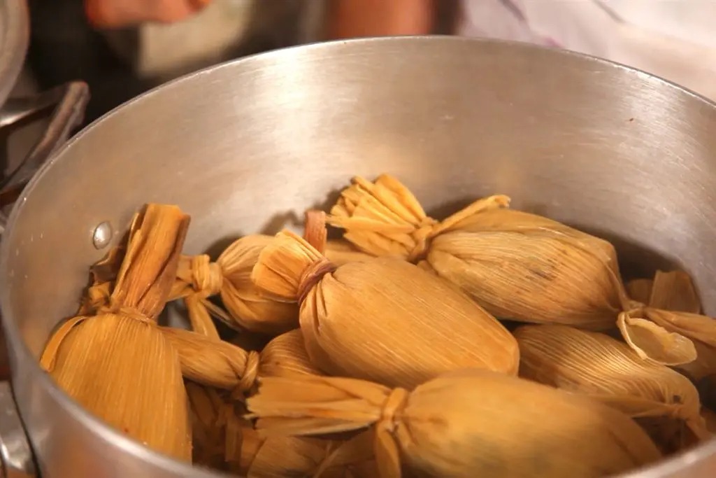 JOven prepara tamales de chipilín